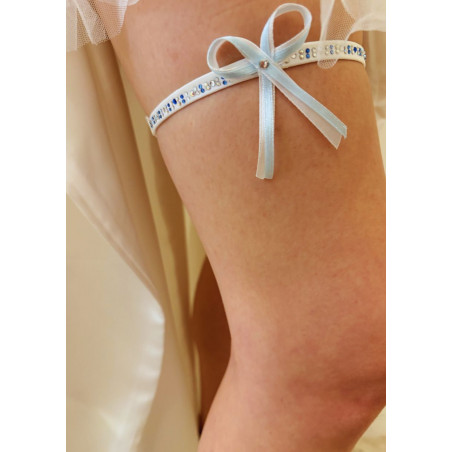 Jarretière de mariée, strass, avec un nœud en ruban fin blanc et bleu.