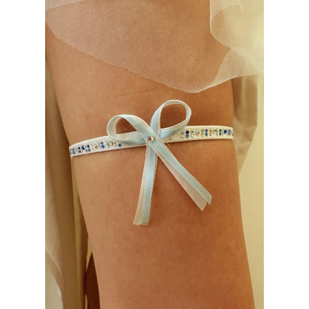 Jarretière de mariée ornée de strass, avec un nœud délicat en ruban fin, blanc et bleu.