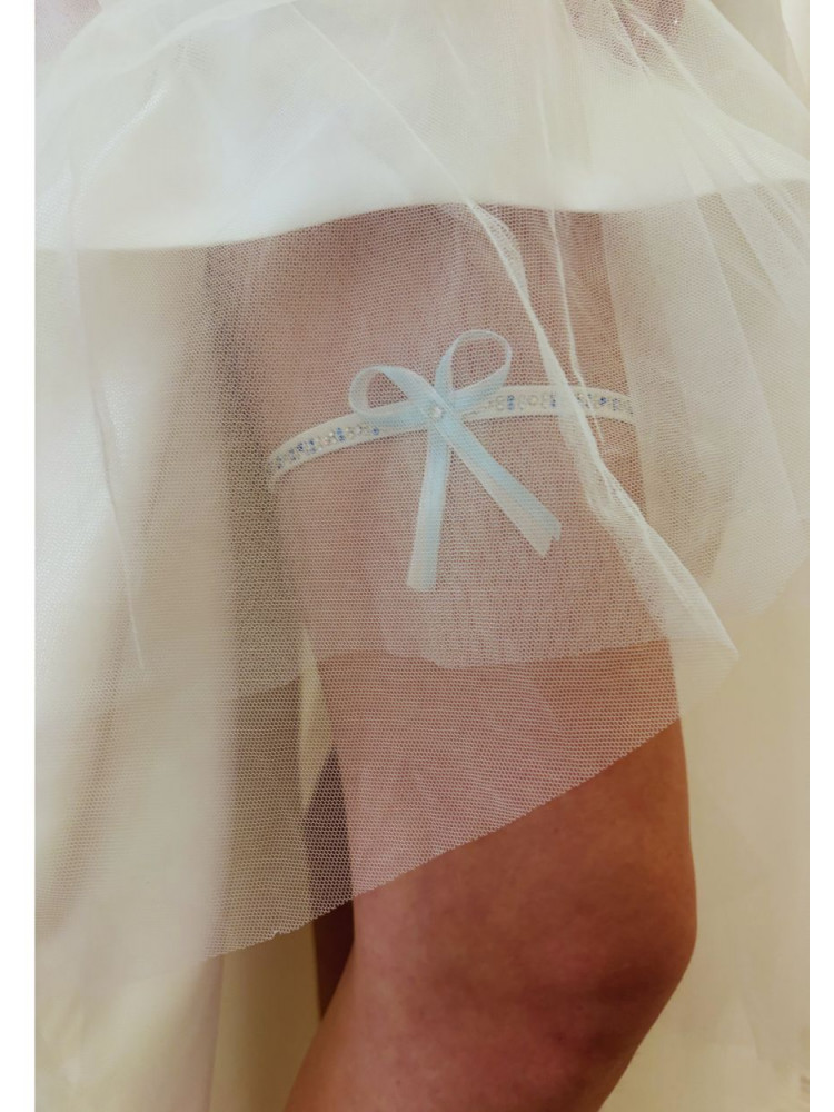 Jarretière de mariée ornée de strass, avec un nœud délicat en ruban fin, blanc et bleu.