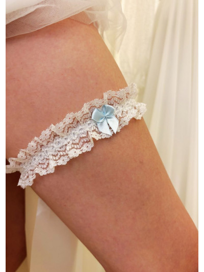 Jarretière de mariée en dentelle blanche, avec un petit nœud en ruban bleu.