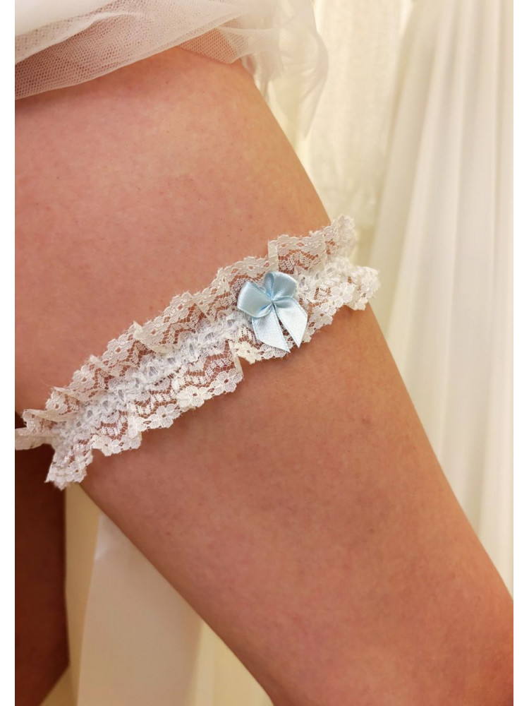 Jarretière de mariée en dentelle blanche, avec un petit nœud en ruban bleu.
