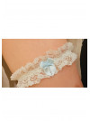 Jarretière de mariée en dentelle blanche, avec un petit nœud en ruban bleu.