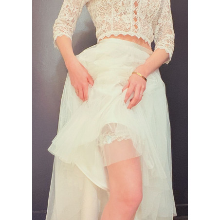 Jarretière de mariée en dentelle blanche, avec un petit nœud en ruban bleu.