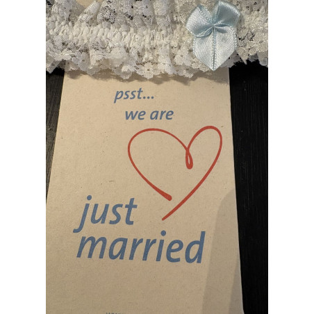 Jarretière de mariée en dentelle blanche, avec un petit nœud en ruban bleu.