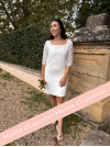 ARTEMIS, Robe de mariée courte en crêpe et guipure géométrique avec des manches 3/4.