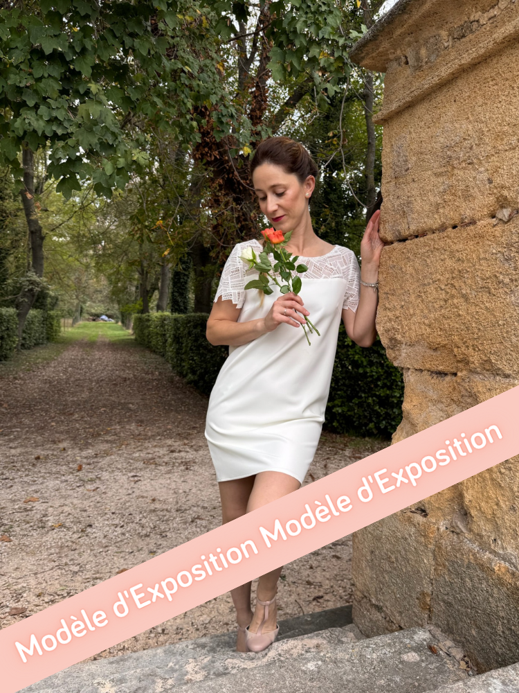 Robe de mariée courte en twill et guipure géométrique avec des manches courtes.