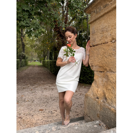 Robe de mariée courte en twill et guipure géométrique avec des manches courtes.