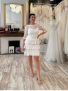 Robe de mariée courte intégralement confectionnée en dentelle.