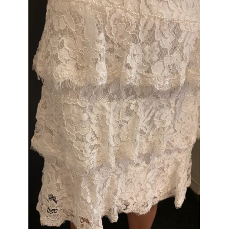 Robe de mariée courte intégralement confectionnée en dentelle.