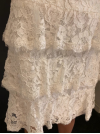 Robe de mariée courte intégralement confectionnée en dentelle.