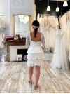 Robe de mariée courte intégralement confectionnée en dentelle.